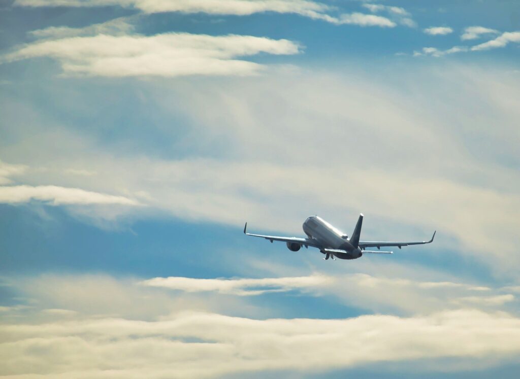 Passenger airplane flying above clouds in a blue sky